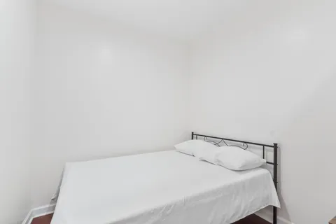 a bedroom with a white bed and a window