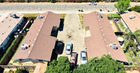 an aerial view of residential houses with outdoor space and ocean view