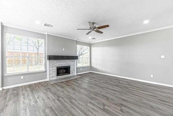 a view of empty room with wooden floor and fireplace