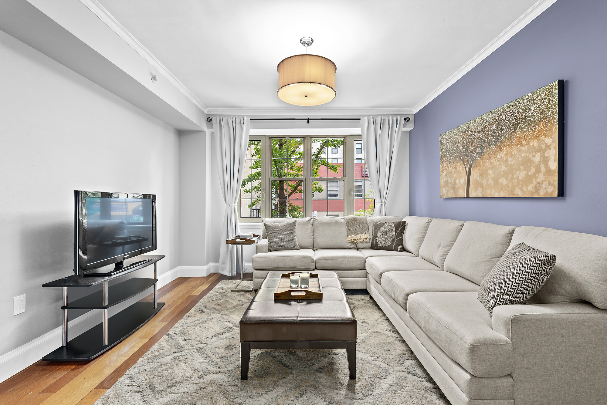163 St Nicholas Avenue, Unit 2J Manhattan, NY 10026 - Photo 1 of 13 a living room with furniture a rug and a flat screen tv