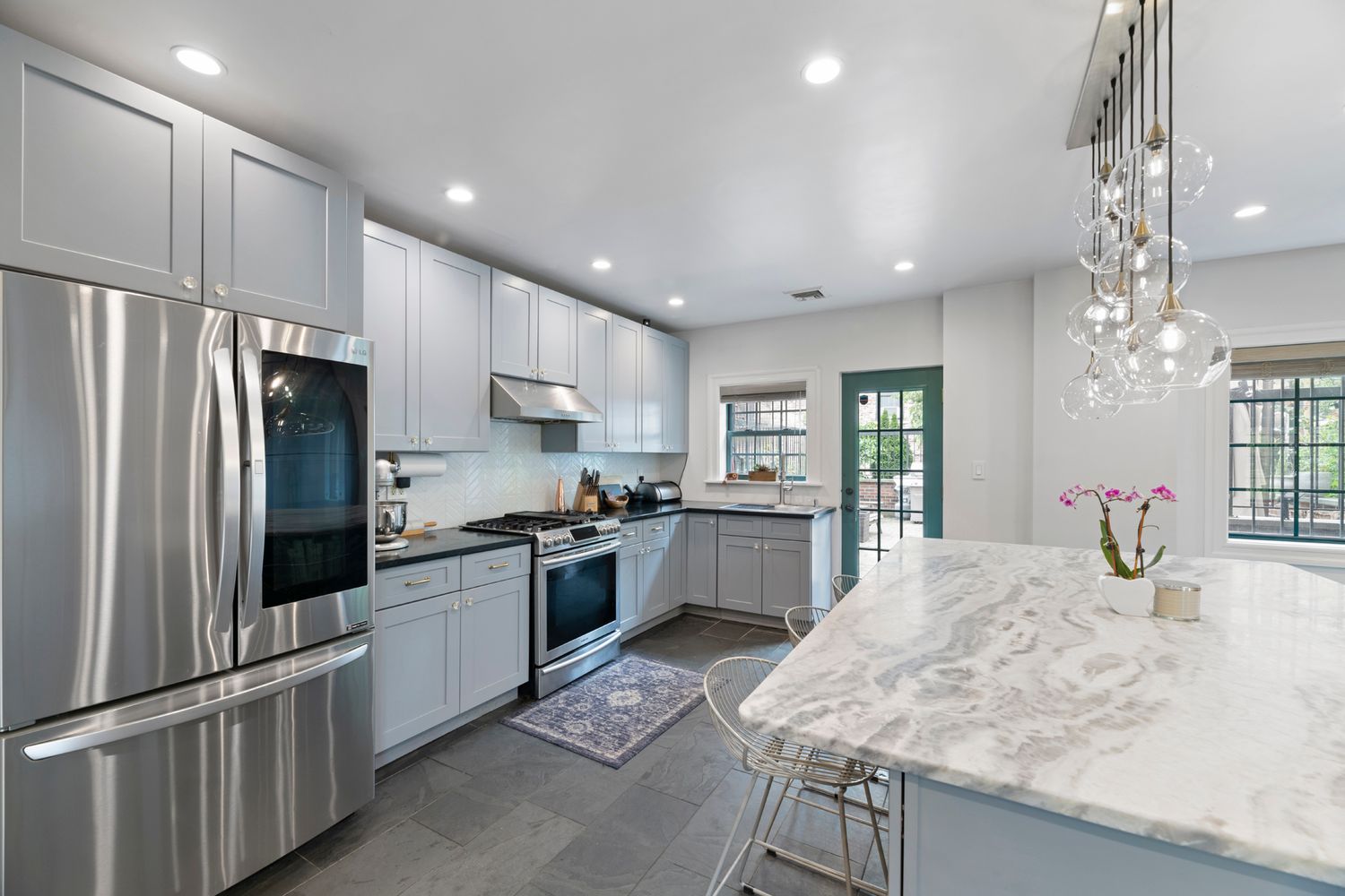 a kitchen with granite countertop a refrigerator stove top oven and sink