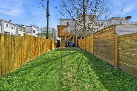 a view of backyard with wooden fence