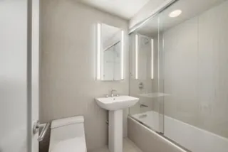a bathroom with a sink a toilet and shower