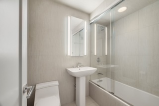 61 Jane Street, Unit 15A Manhattan, NY 10014 - Photo 7 of 10 a bathroom with a sink a toilet and shower