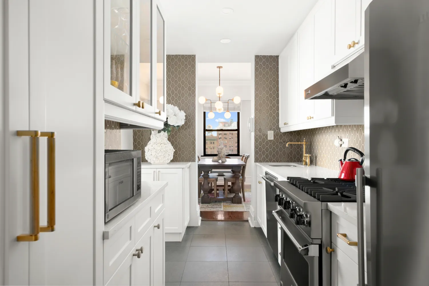 a kitchen with stainless steel appliances a refrigerator a stove and white cabinets