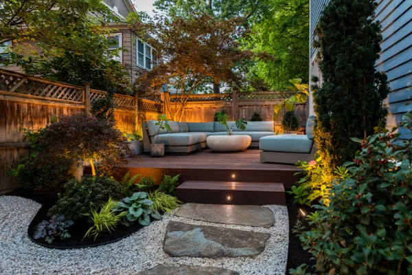 a view of a patio with couches table and chairs potted plants and large tree