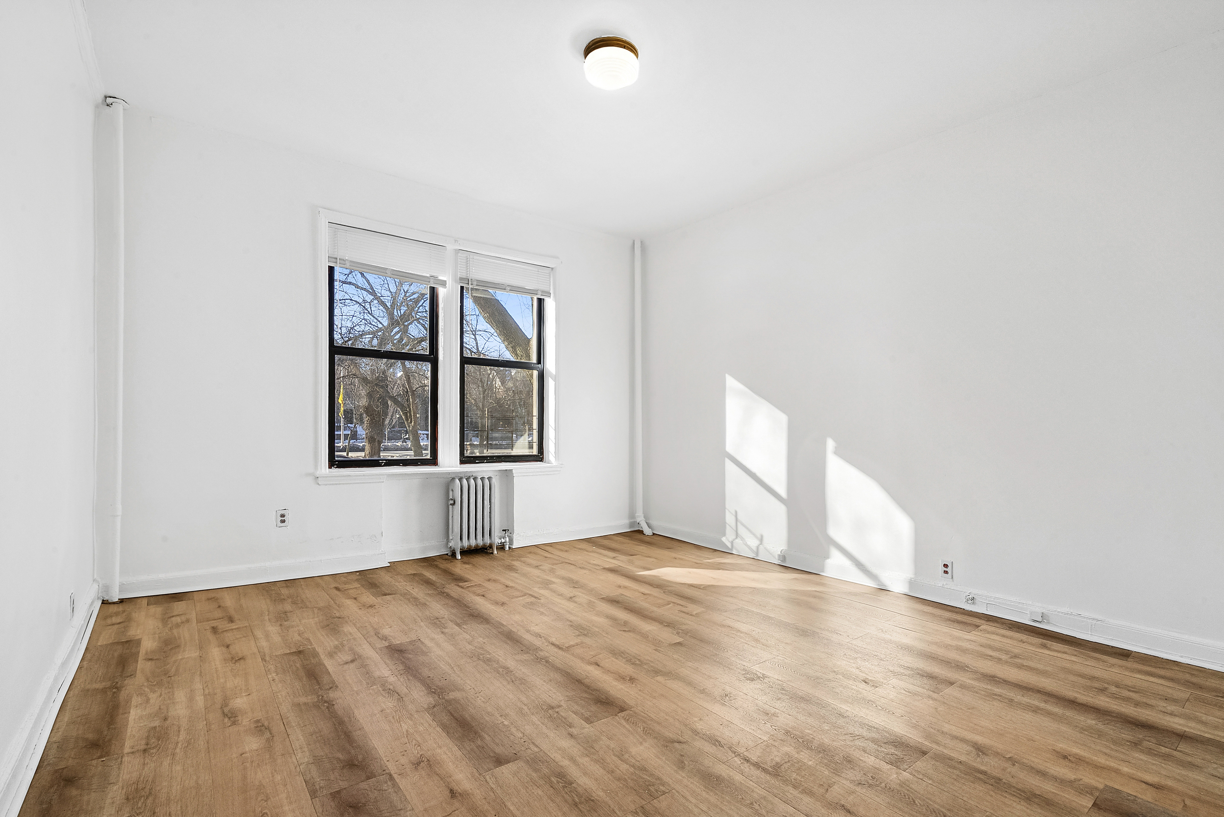 773 Eastern Parkway, Unit 1A Brooklyn, NY 11213 - Photo 8 of 11 a view of an empty room with a window and wooden floor