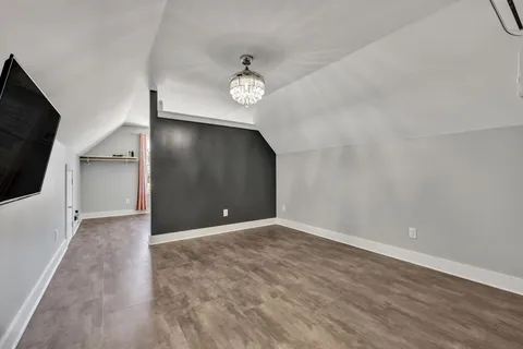 an empty room with wooden floor and a ceiling fan