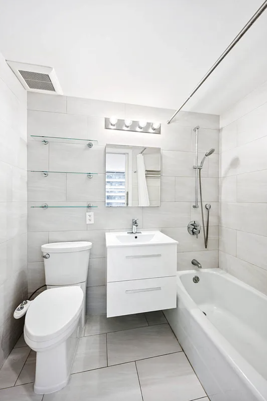 159 East 53rd Street, Unit 10A Manhattan, NY 10022 - Photo 5 of 10 a bathroom with a sink a toilet and bathtub