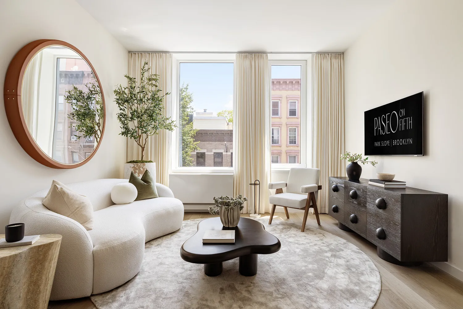 a living room with furniture a flat screen tv and a large window