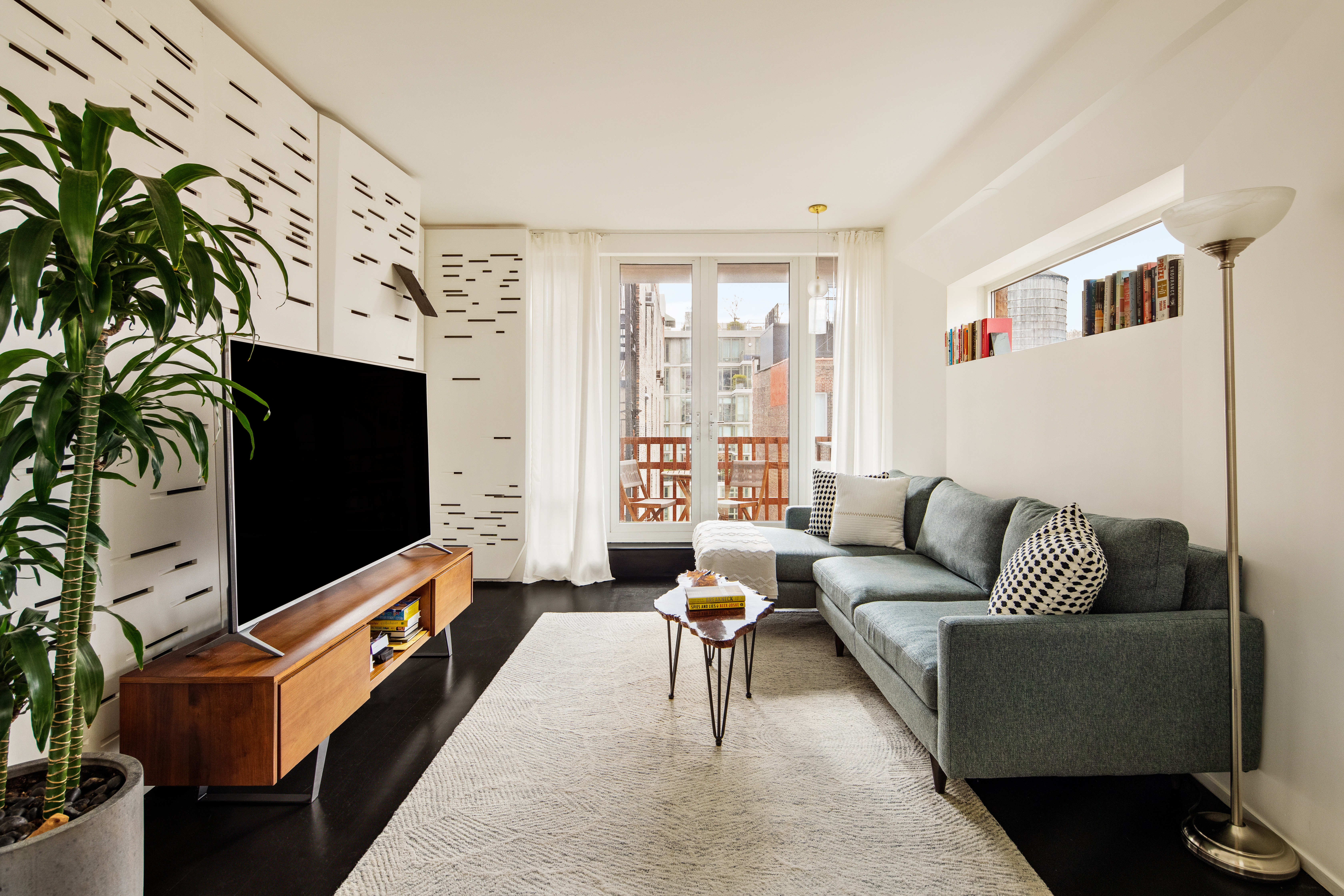 a living room with furniture flat screen tv and a chandelier