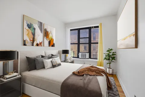 a bedroom with bed and a painting on the wall