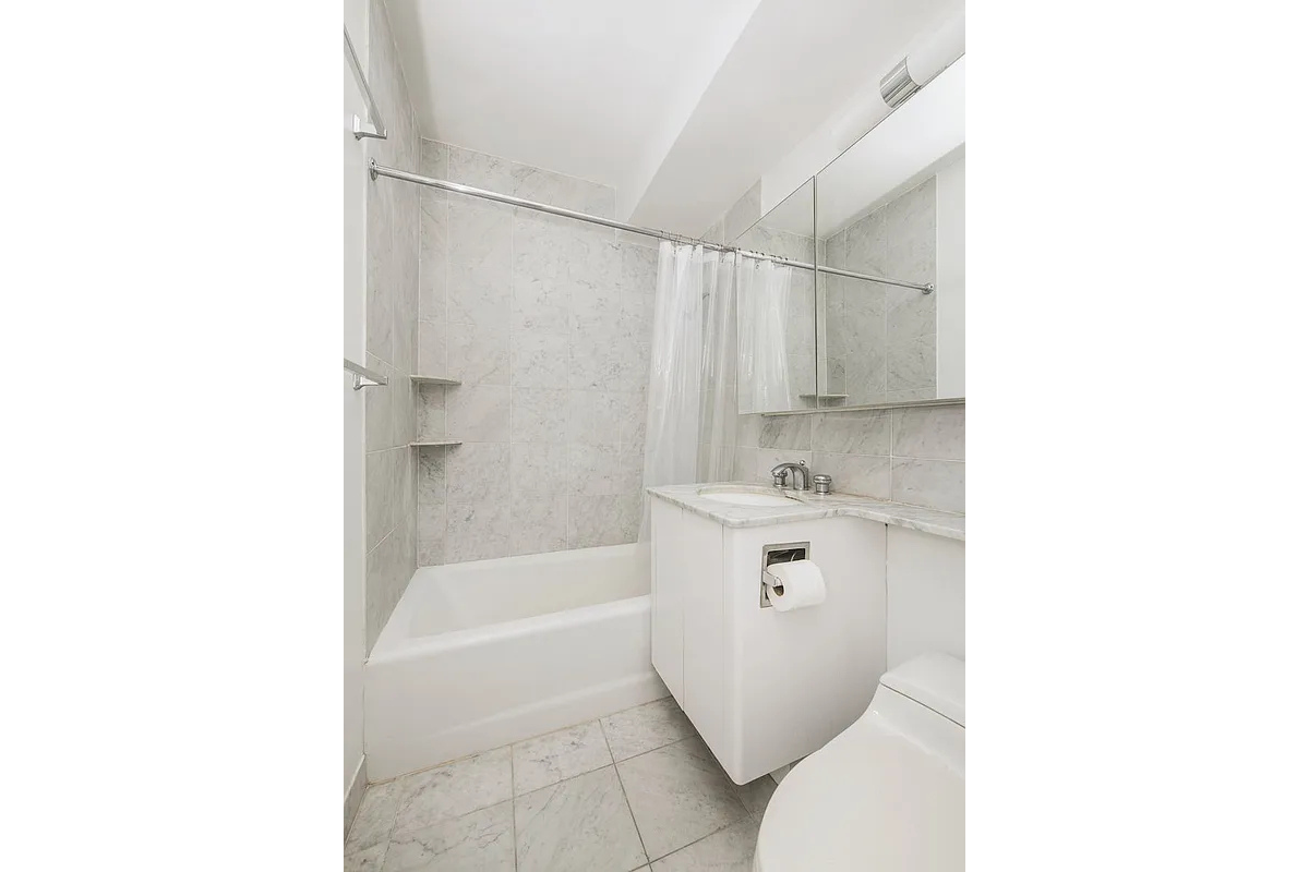 211 East 53rd Street, Unit 14B Manhattan, NY 10022 - Photo 4 of 8 a bathroom with a sink toilet and shower
