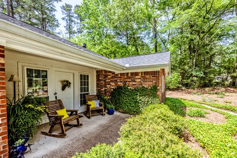 a view of a house with backyard sitting area and garden