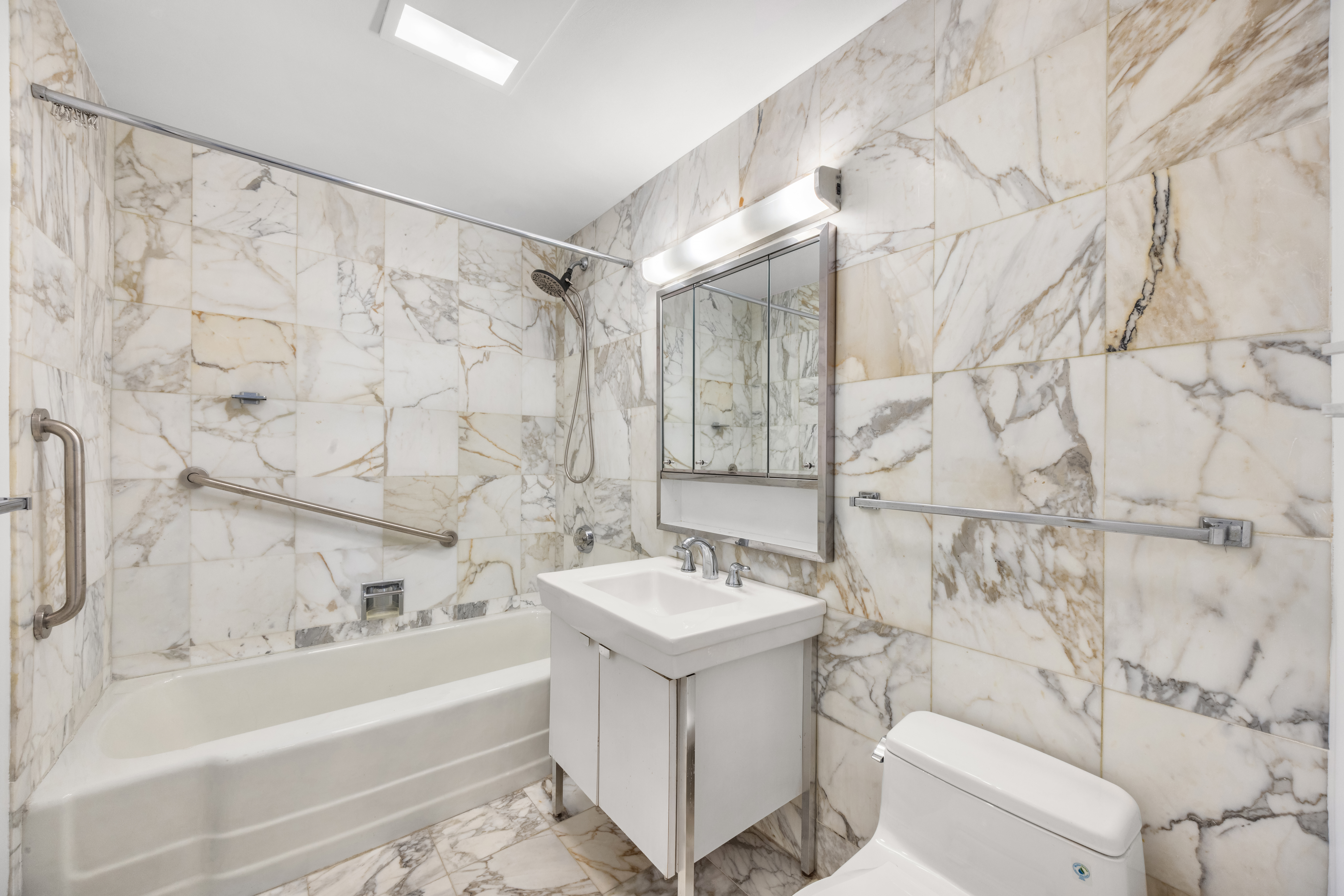870 United Nations Plaza, Unit 14F Manhattan, NY 10017 - Photo 8 of 16 a bathroom with a sink toilet and shower