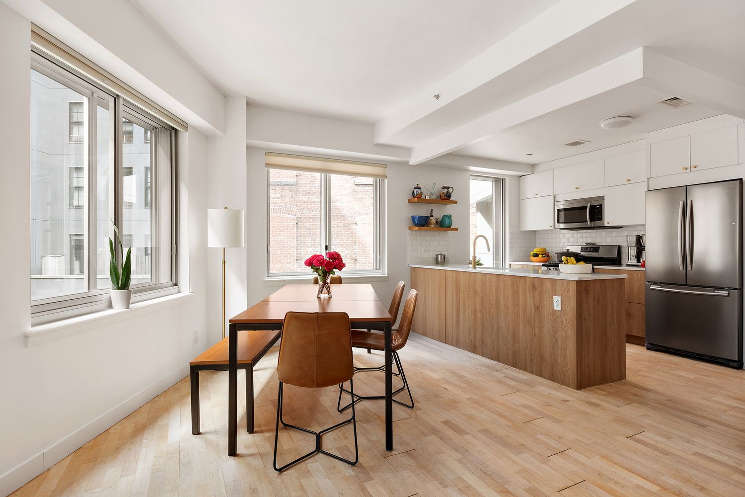 a kitchen with a table chairs refrigerator and microwave