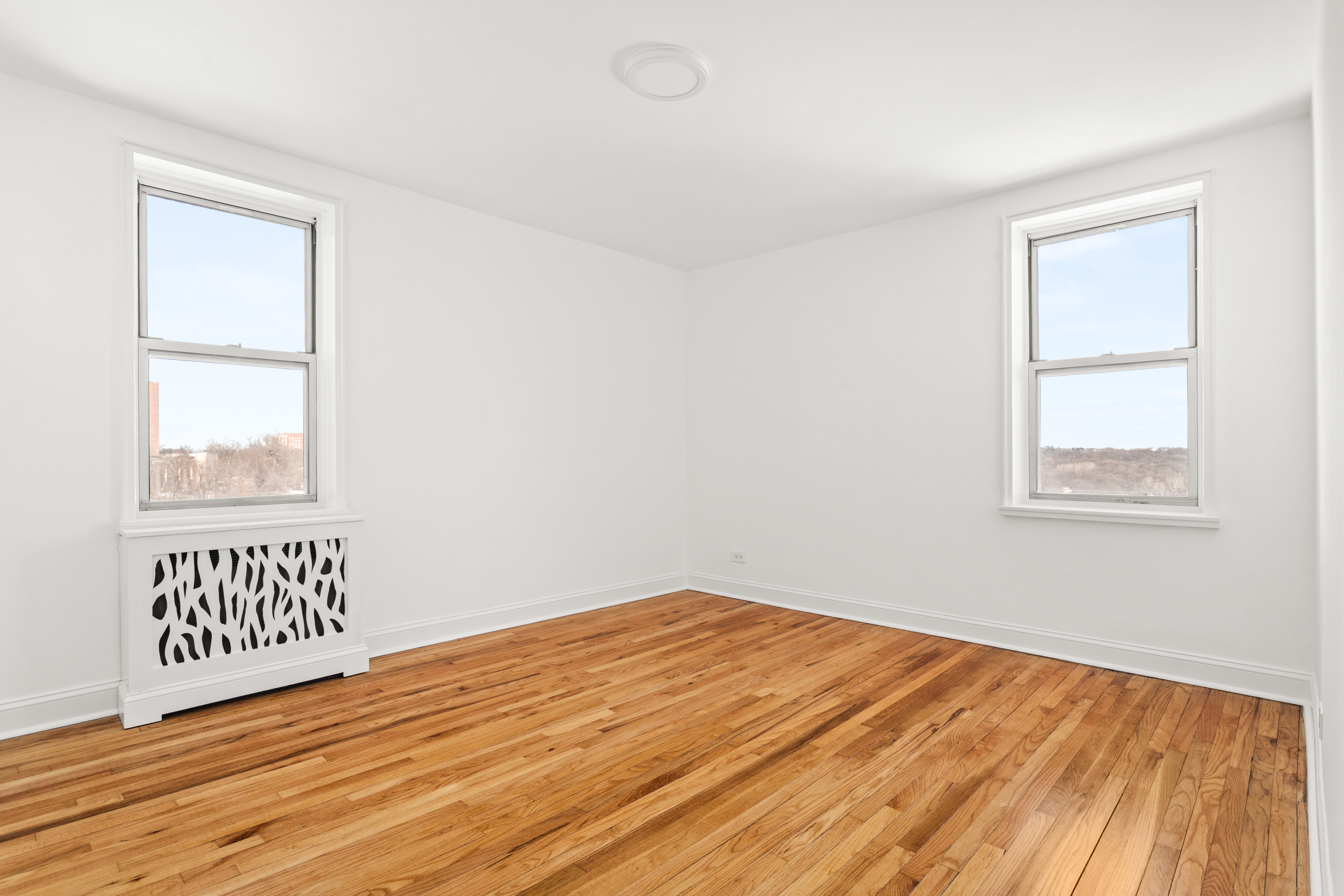 5650 Netherland Avenue, Unit 6C Bronx, NY 10471 - Photo 13 of 16 an empty room with wooden floor and windows