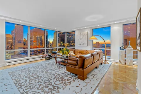 a living room with furniture and a floor to ceiling window