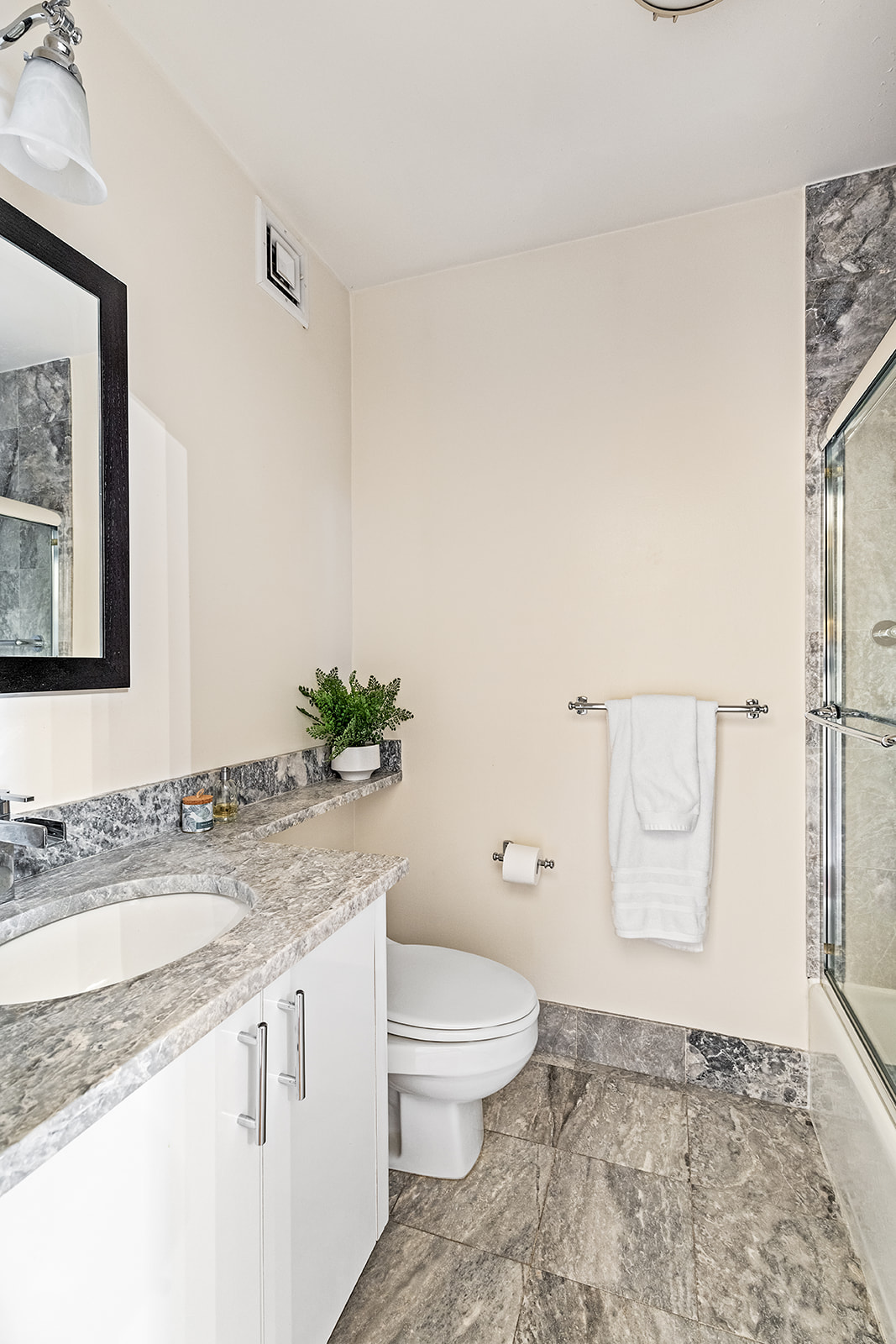 350 East 72nd Street, Unit 12A Manhattan, NY 10021 - Photo 8 of 9 a bathroom with a granite countertop sink a toilet and a mirror
