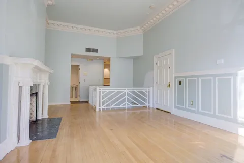 a view of a room with wooden floor and windows