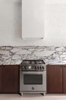 a stove top oven sitting inside of a kitchen