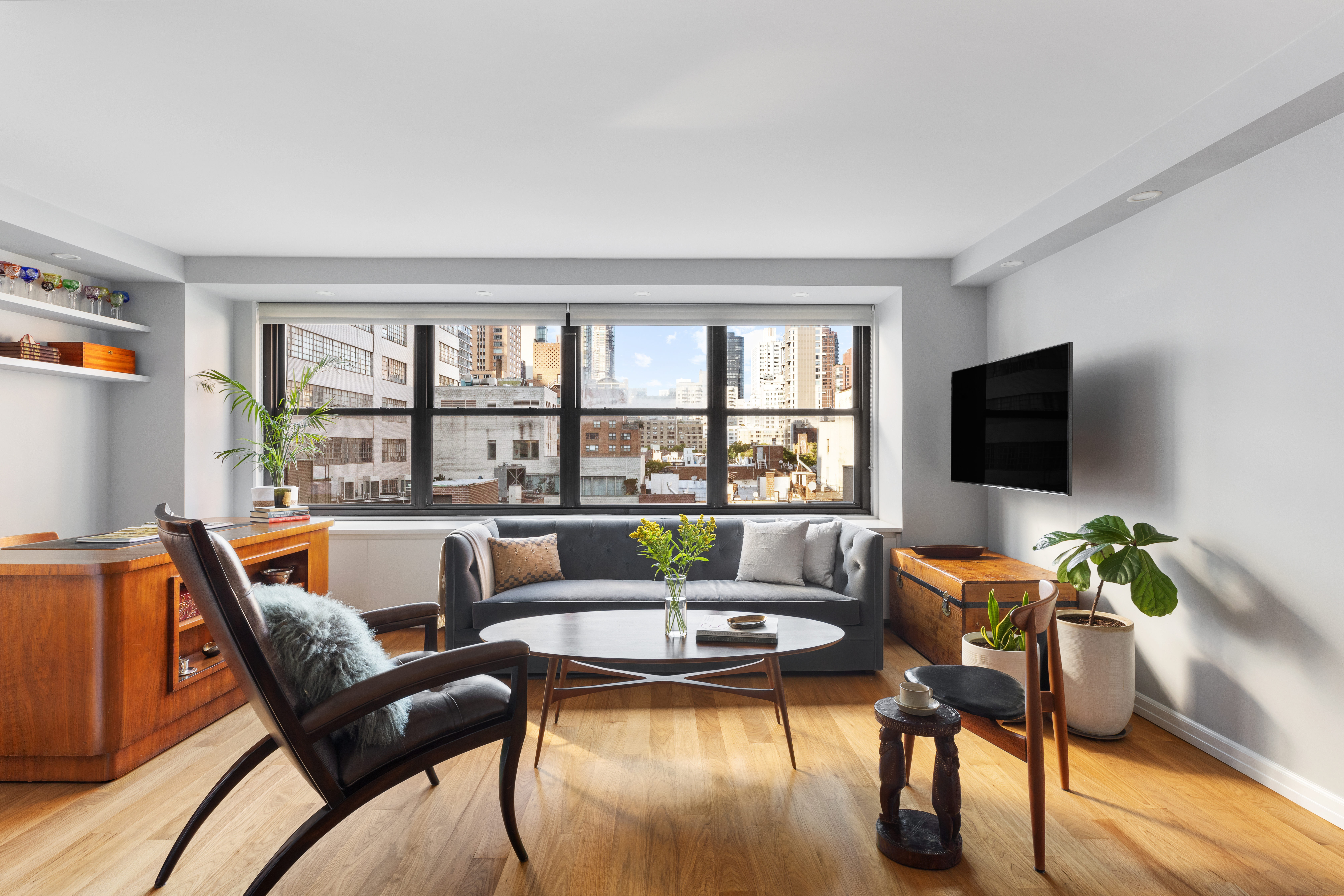 225 East 57th Street, Unit 9M Manhattan, NY 10022 - Photo 2 of 10 a living room with furniture and a flat screen tv