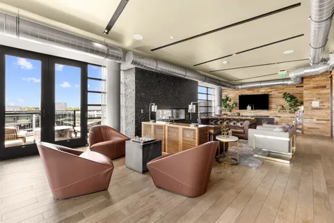 a living room with furniture wooden floor and a large window