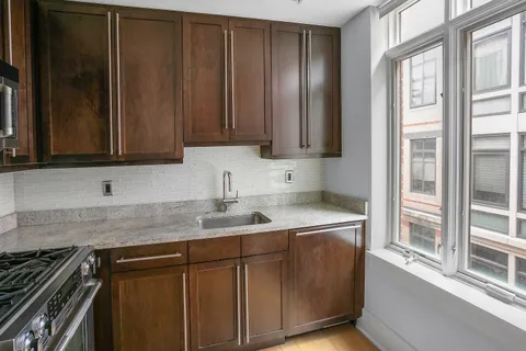 a kitchen with stainless steel appliances granite countertop a sink stove and cabinets