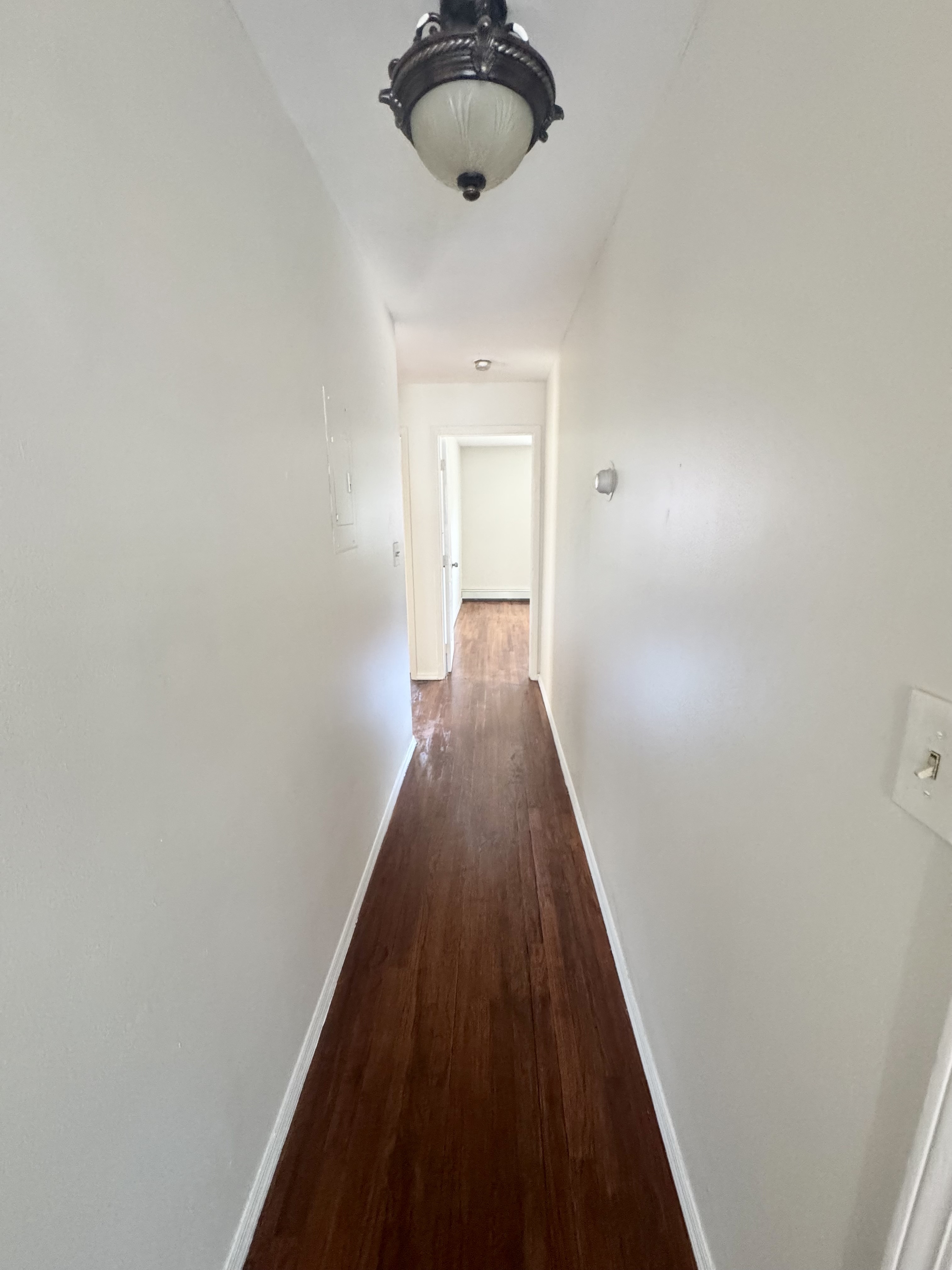 156-17 76th Street, Unit 1 Queens, NY 11414 - Photo 12 of 12 a view of a hallway with wooden floor and a chandelier
