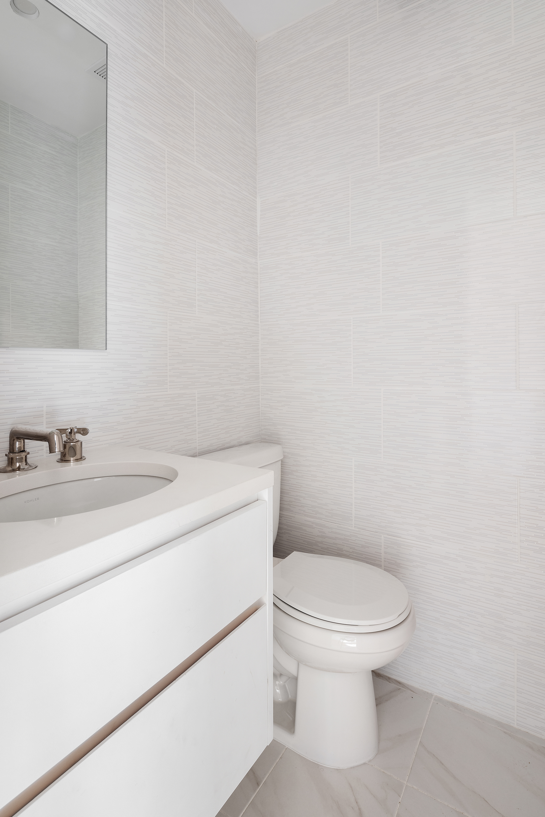 55 Liberty Street, Unit 13C Manhattan, NY 10005 - Photo 8 of 9 a bathroom with a sink a toilet and a mirror