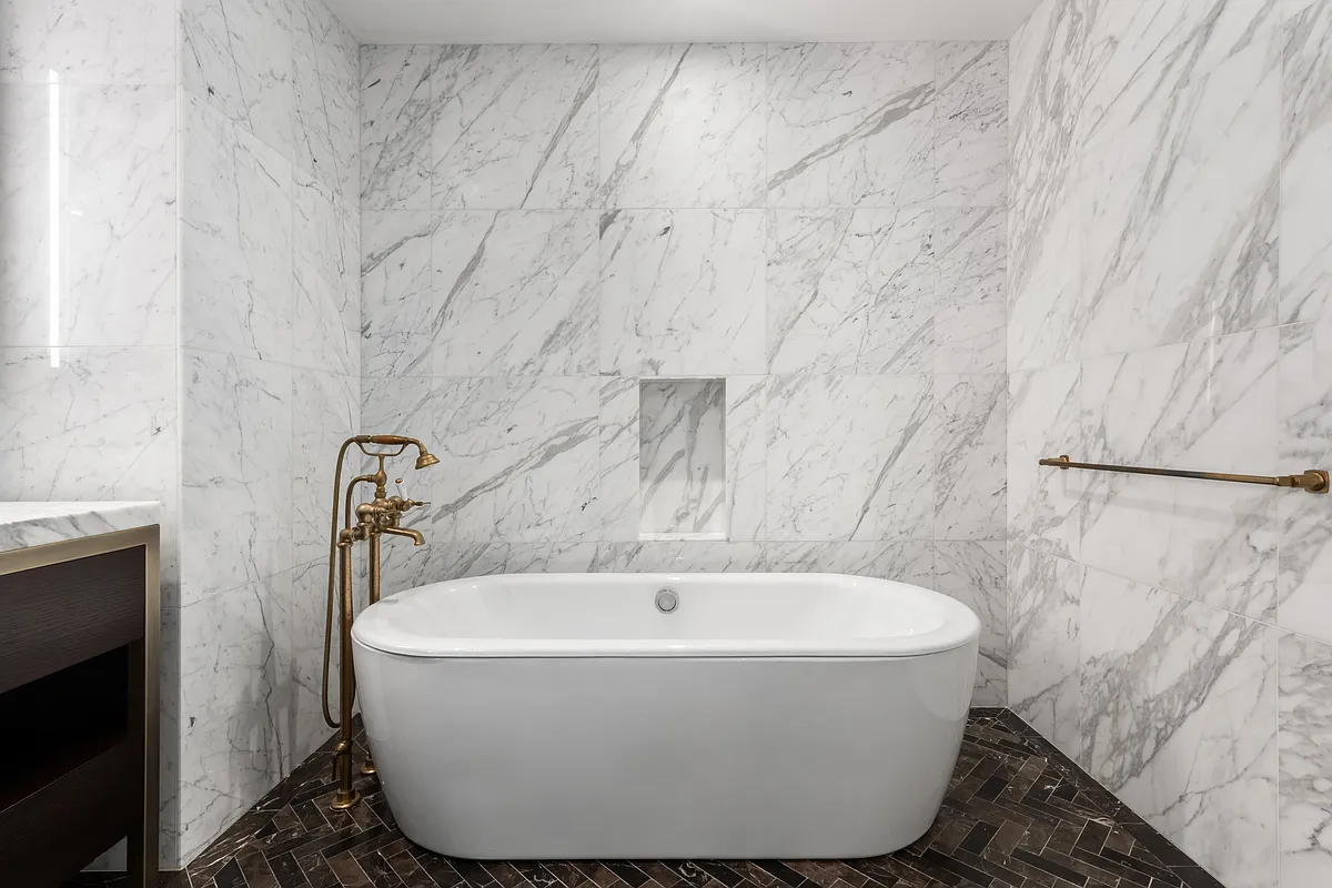 500 West 21st Street, Unit 2G Manhattan, NY 10011 - Photo 9 of 21 a white bath tub sitting in a bathroom