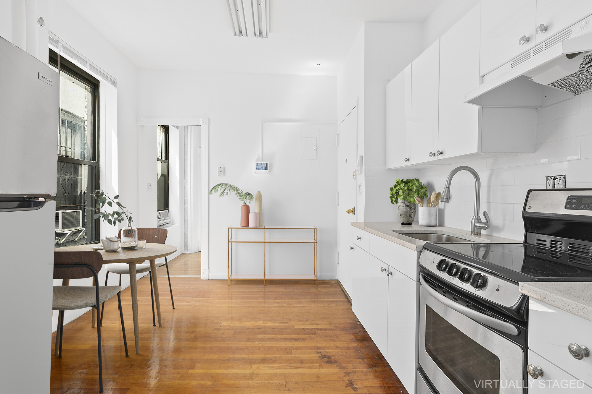 1315 3rd Avenue, Unit PH5RN Manhattan, NY 10021 - Photo 3 of 7 a kitchen with stainless steel appliances a stove a sink white cabinets and wooden floors