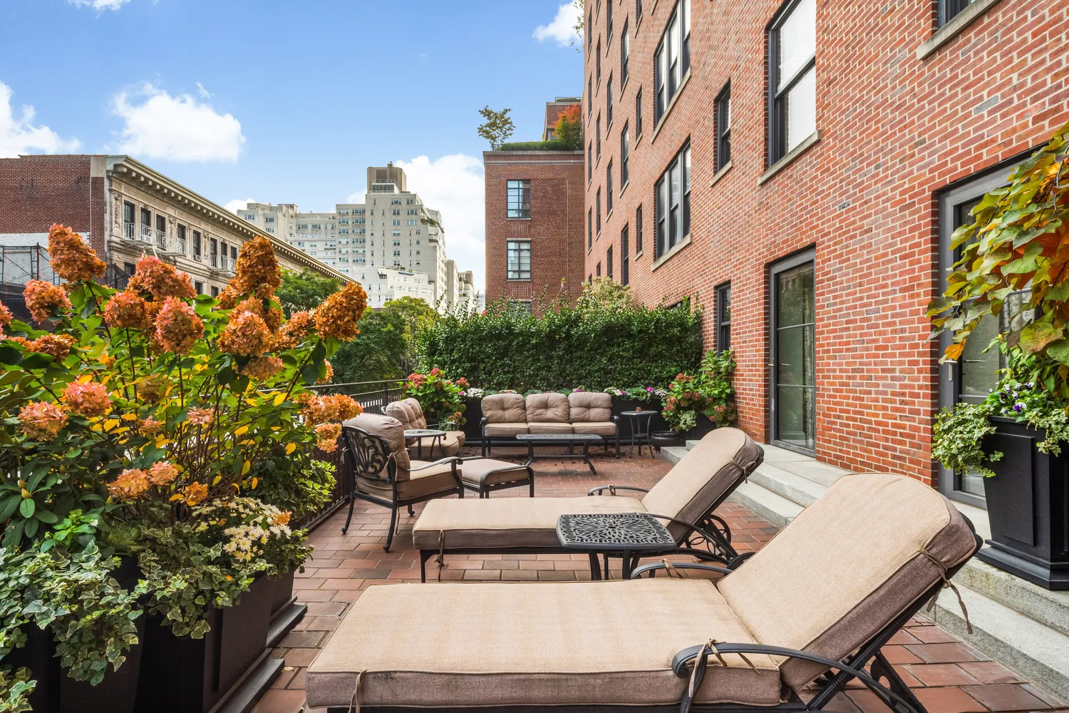 a view of a patio with couches table and chairs and potted plants
