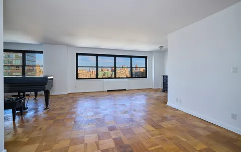 an empty room with windows and fireplace
