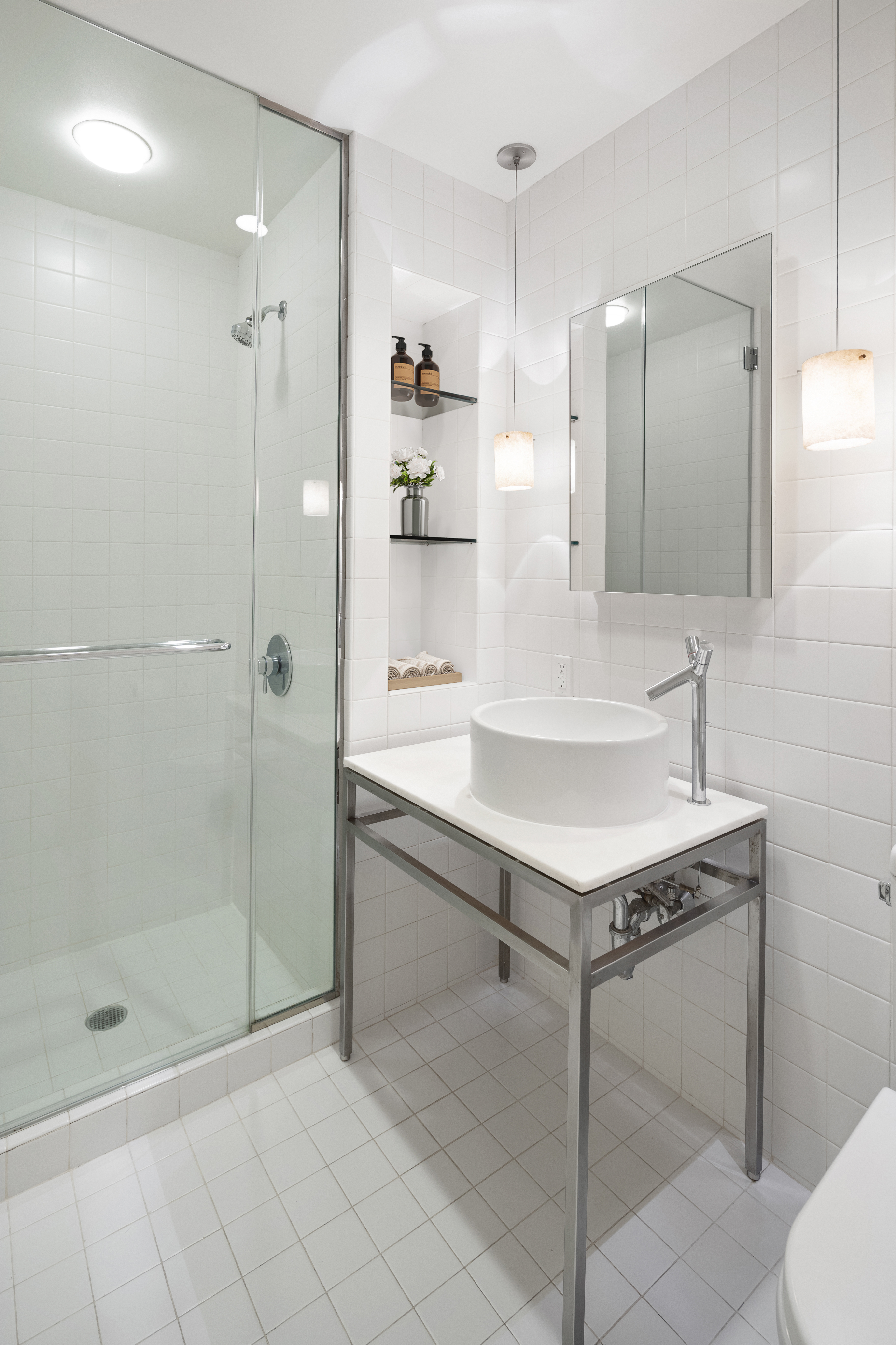 15 Broad Street, Unit 2926 Manhattan, NY 10005 - Photo 10 of 26 a bathroom with a shower sink and mirror
