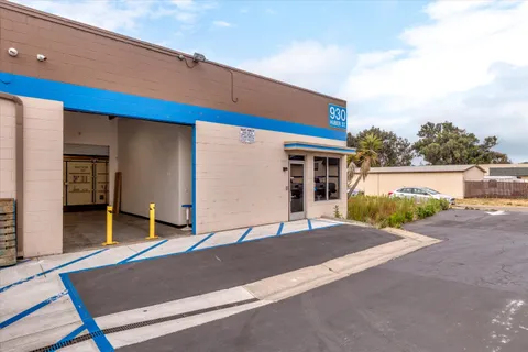 a view of a house with a floor to ceiling window and potted plants