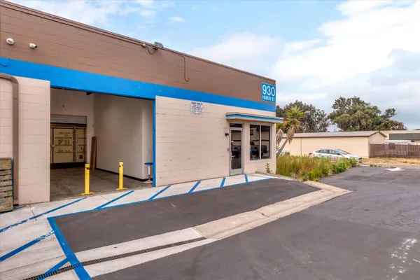 a view of a house with a floor to ceiling window and potted plants