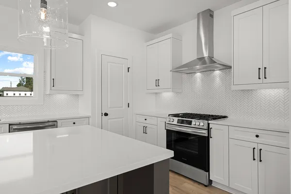 a kitchen with stainless steel appliances a stove a sink and cabinets