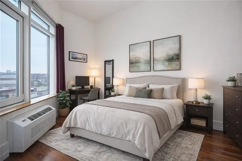 a bedroom with a bed and a large window