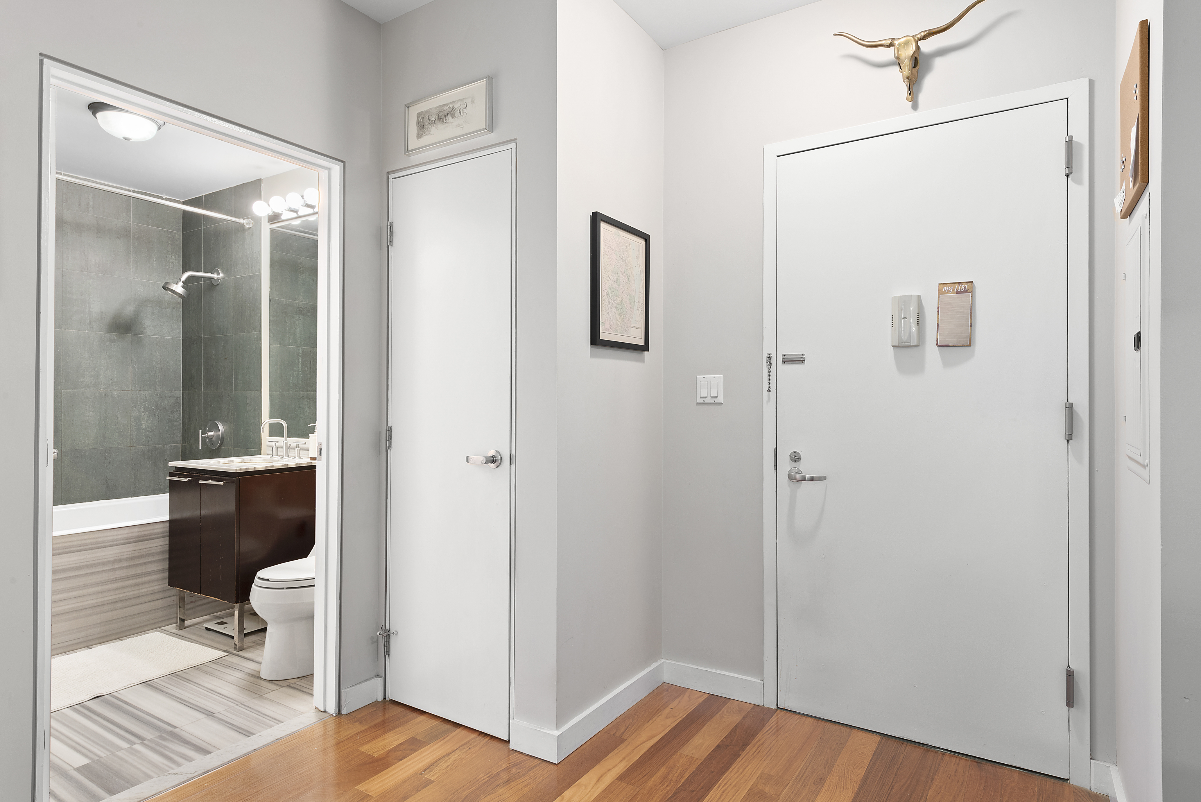 2-40 51st Avenue, Unit 2N Queens, NY 11101 - Photo 6 of 10 a view of a hallway with wooden floor and bathroom