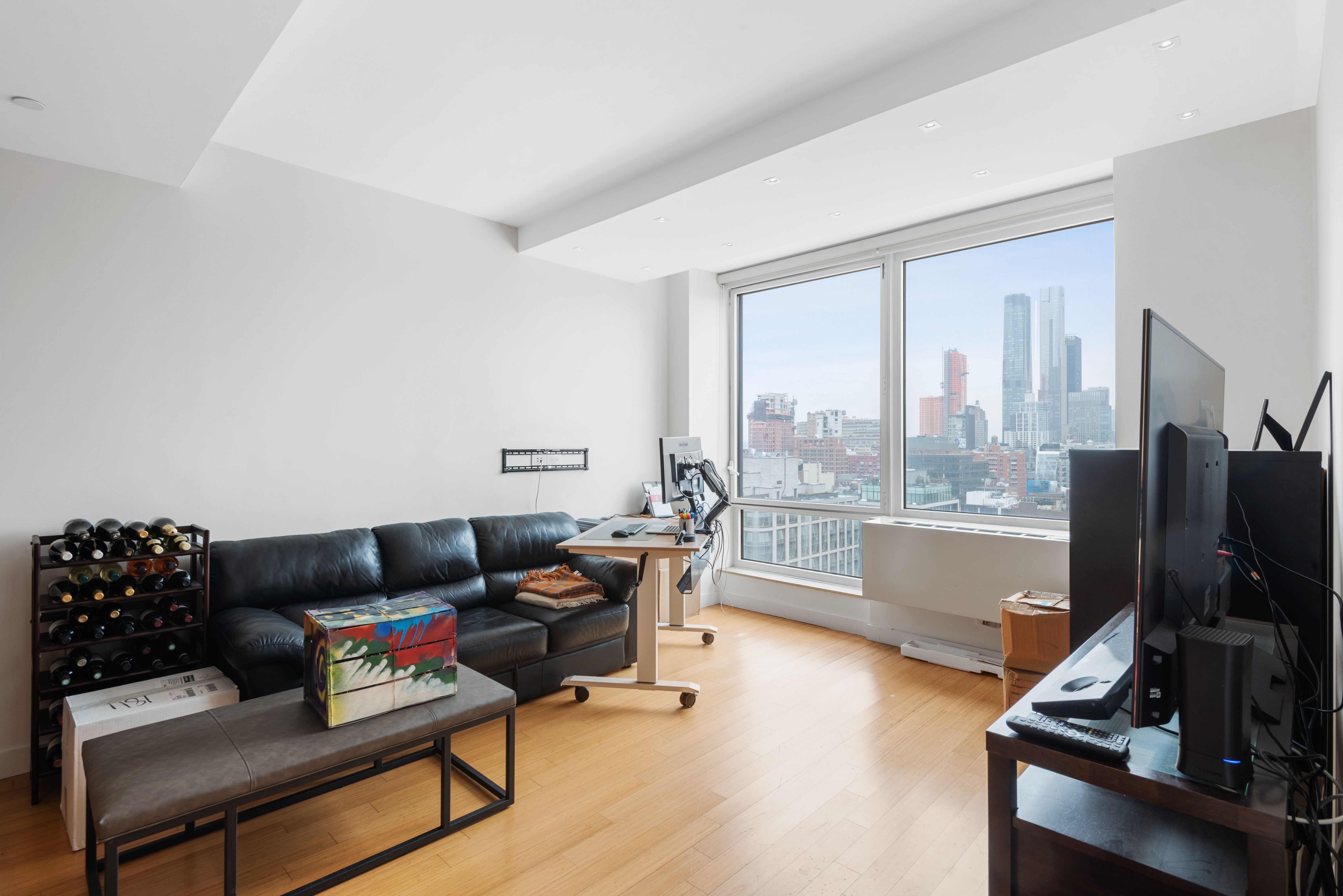450 West 17th Street, Unit 1811 Manhattan, NY 10011 - Photo 3 of 14 a living room with furniture and a flat screen tv