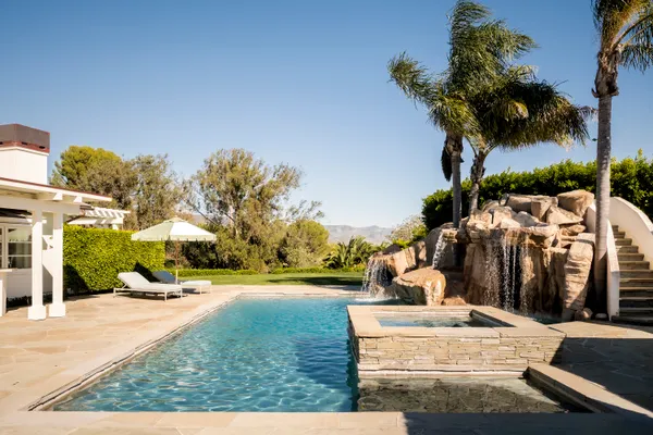a backyard of a house with swimming pool and furniture