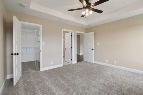 an empty room with closet and a chandelier fan