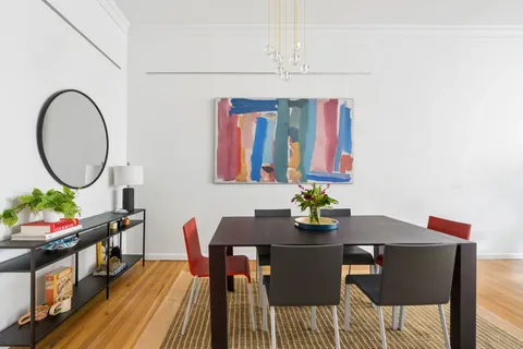 a dining room with furniture a rug and a mirror