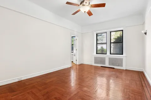 an empty room with window and a ceiling fan
