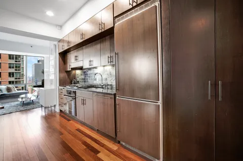 a kitchen with kitchen island granite countertop stainless steel appliances and wooden floor