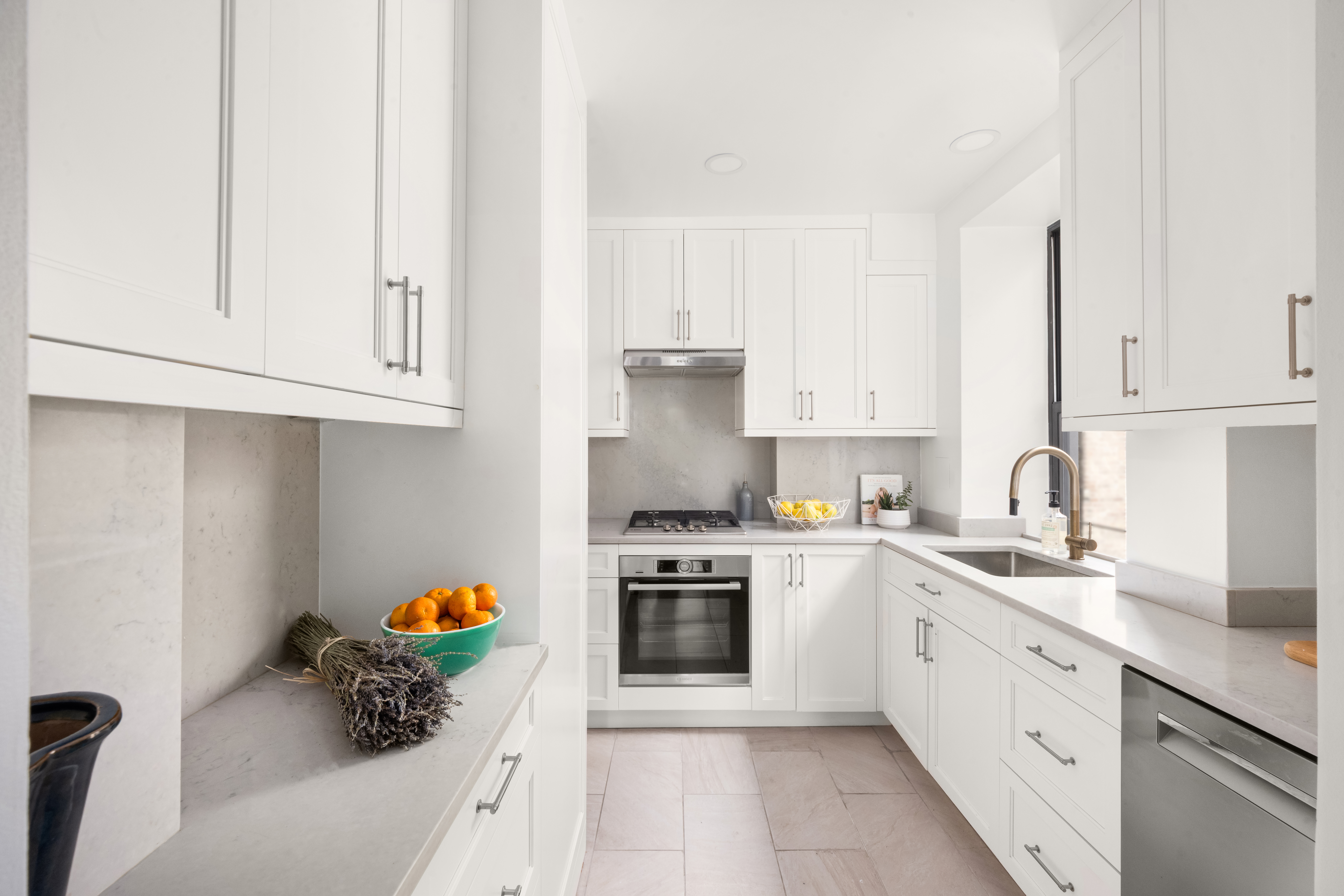 119 West 71st Street, Unit 9B Manhattan, NY 10023 - Photo 6 of 18 a kitchen with granite countertop white cabinets and white appliances