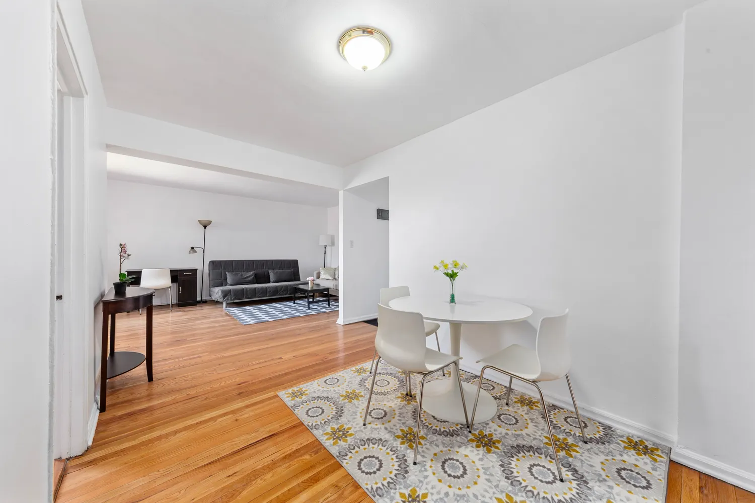 a living room with furniture and a dining table with wooden floor