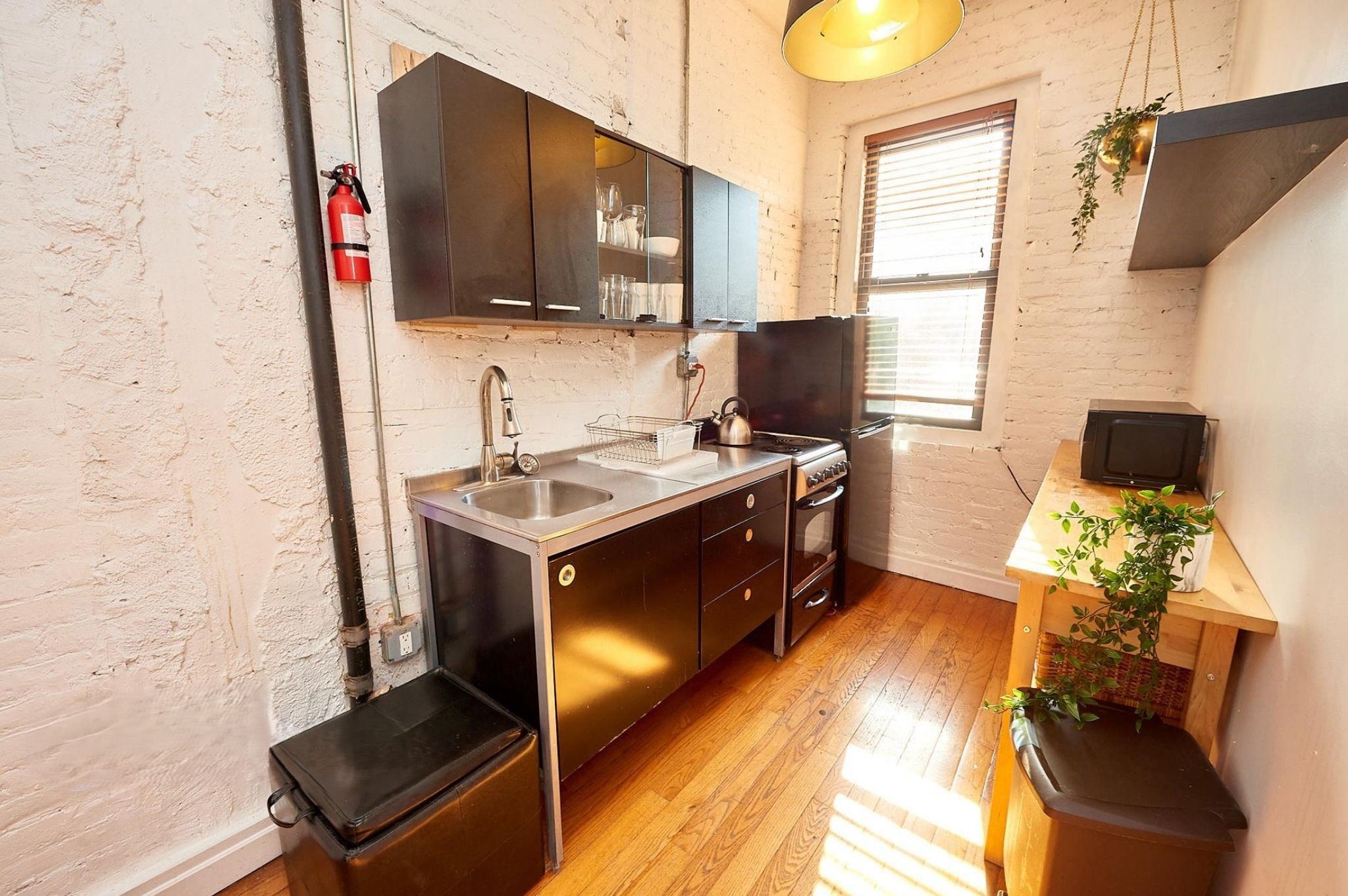 170 Elizabeth Street, Unit 1 Manhattan, NY 10012 - Photo 4 of 16 a kitchen with stainless steel appliances a stove a sink and a microwave