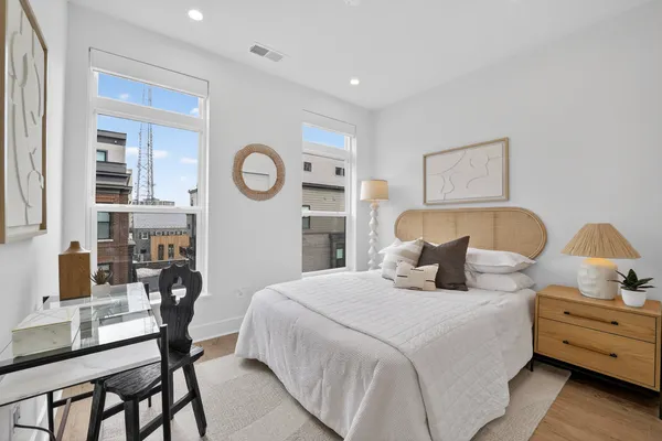 a bedroom with a bed and a table with potted plants